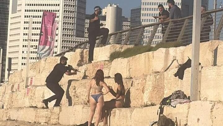 מתרחצים מפונים במהלך הצהרת נתניהו (צילום: שימוש לפי סעיף 27א' בחוק זכויות יוצרים) מאבטח מכוון את נשקו על מתרחצים