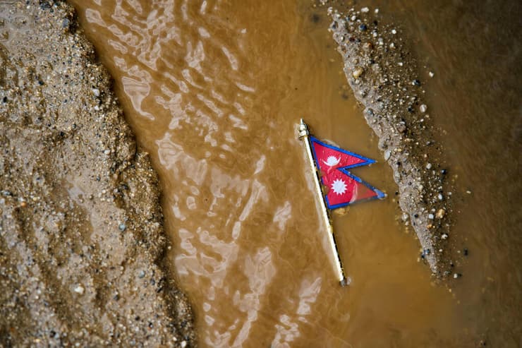 דגל נפאל מוטל במים ובבוץ (צילום: AP Photo/Niranjan Shrestha) דגל נפאל מוטל במים ובבוץ