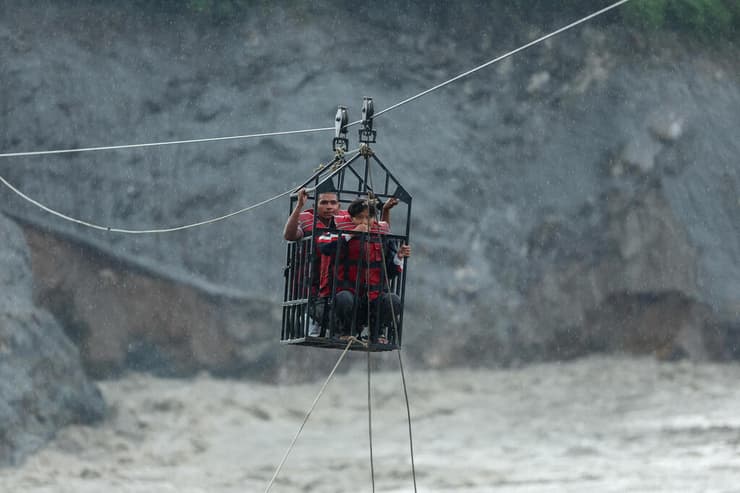 צילום: REUTERS/Francis Mascarenhas נפאל אסון שיטפון גבול טיבט מפונים חוצים את נהר הטרישולי בכלוב על אומגה מאולתרת