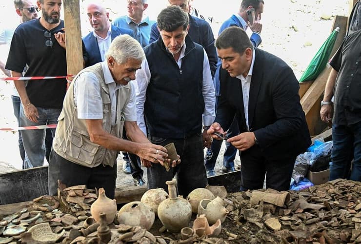 ראש עיריית טביליסי קאחה קלאדזה (במרכז) מתרשם מכלי החרס העתיקים שהתגלו בעיר (צילום: Irakli Gedenidze/Reuters) ראש עיריית טביליסי קאחה קלאדזה (במרכז) מתרשם מכלי החרס העתיקים שהתגלו בעיר