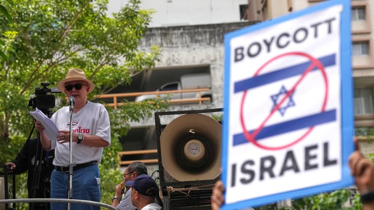 בשבוע שעבר: הפגנה סוערת בבנגקוק נגד ישראל (AP Photo/Sakchai Lalit) סונדהי לימטונגקול, איש תקשורת ופעיל פוליטי, נואם מול תומכיו בהפגנה מול שגרירות ישראל בבנגקוק