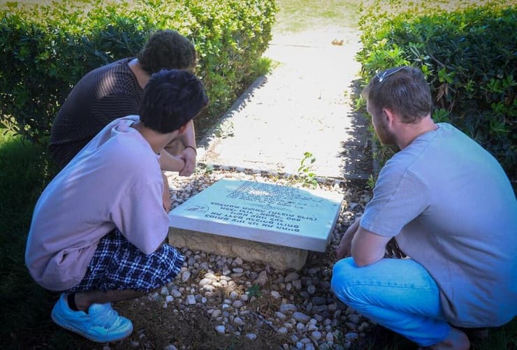 לוחמי פלוגה א' ליד האנדרטה בבית ליד לחללי הגדוד שנפלו במלחמה. "אלה חברים שהיית נותן את החיים שלך כדי שלא יקבלו כדור" (צילום: אביגיל עוז) עומדים ליד אנדרטה זיכרון לחללי ה גדוד ש נהרגו ב מלחמת חרבות ברזל ב בסיס בית ליד