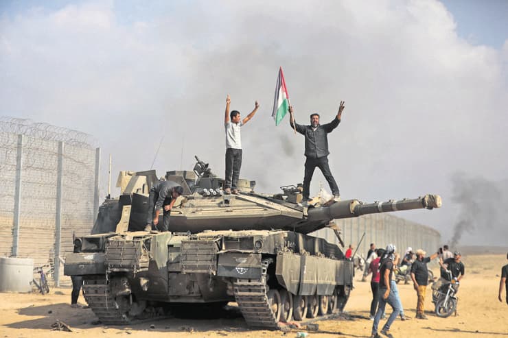 מחבלי חמאס על טנק של צה"ל בעוטף, 7 באוקטובר 2023 (צילום: Yousef Masoud/AP) מחבלי חמאס על טנק של צה"ל בעוטף, 7 באוקטובר 2023