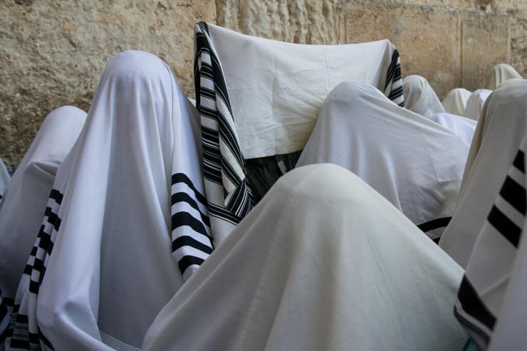 מתפללים עטופים בטליתות ברחבת הכותל המערבי (צילום: אוהד צויגנברג) מתפללים עטופים בטליתות ברחבת הכותל המערבי