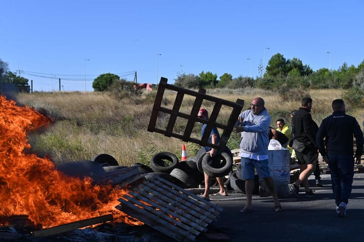 צילום: Sylvain THOMAS / AFP 17 בספטמבר מפגינים בדרום צרפת ליד העיר סט חוסמים גישה למסוף נפט עם צמיגים בוערים משבר נפט