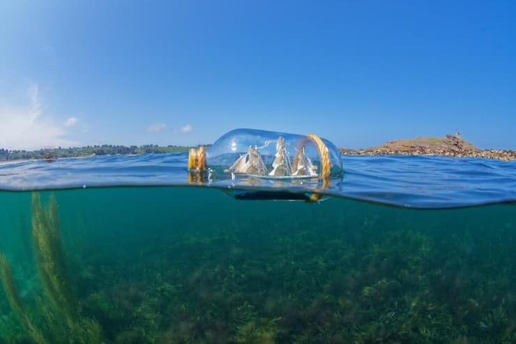 ספינה בתוך בקבוק, צפה על פני הים (צילום: vavea photography/Shutterstock) ספינה בתוך בקבוק, צפה על פני הים