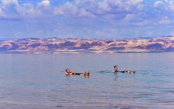 אדם שטובל בים המלח צריך לדחוק נפח קטן למדי של מים כדי שכוח הציפה יאזן את משקלו. אנשים צפים בים המלח (צילום: akturer/Shutterstock) אדם שטובל בים המלח צריך לדחוק נפח קטן למדי של מים כדי שכוח הציפה יאזן את משקלו. אנשים צפים בים המלח