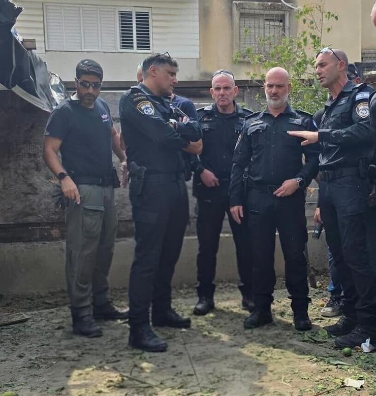 מפקד מחוז ת"א ניצב סרגרוף (שני מימין) בזירה בחולון (צילום: דוברות המשטרה) נער נפצע מפיצוץ מטען בביתו בחולון