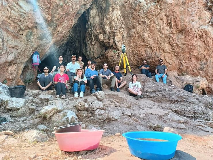 "הממצאים שלנו מצביעים על אינטראקציה תרבותית עמוקה". החוקרים יושבים בפתח מערת אוּצָ'זְלָה 2 (צילום: KyotoU/Naoki Morimoto) "הממצאים שלנו מצביעים על אינטראקציה תרבותית עמוקה". החוקרים יושבים בפתח מערת אוּצָ'זְלָה 2