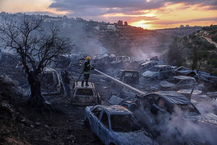 השריפה בעין יברוד, אתמול (צילום: Zain JAAFAR / AFP) לוחם אש פלסטיני פועל לכיבוי שריפה במגרש גרוטאות עין יברוד שליד רמאללה