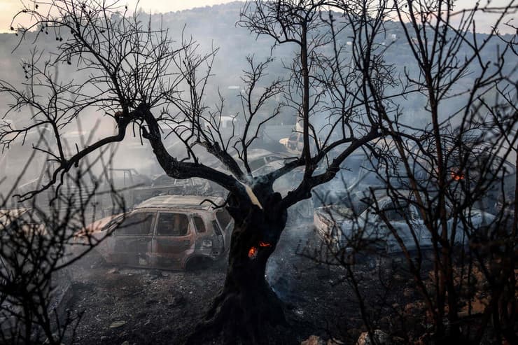 צילום: Zain JAAFAR / AFP לוחם אש פלסטיני פועל לכיבוי שריפה במגרש גרוטאות עין יברוד שליד רמאללה