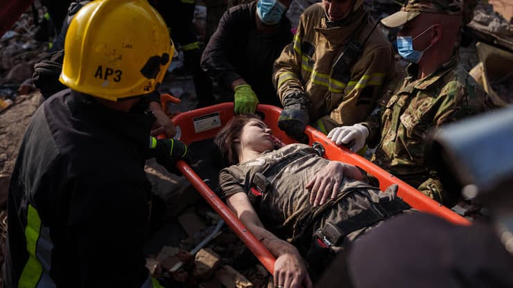 אחת הפצועות מפונה על ידי כוחות ההצלה (צילום: AP Photo/Evgeniy Maloletka) תקיפה של רוסיה החריבה בניין מגורים בעיר פרילוקי ב אוקראינה