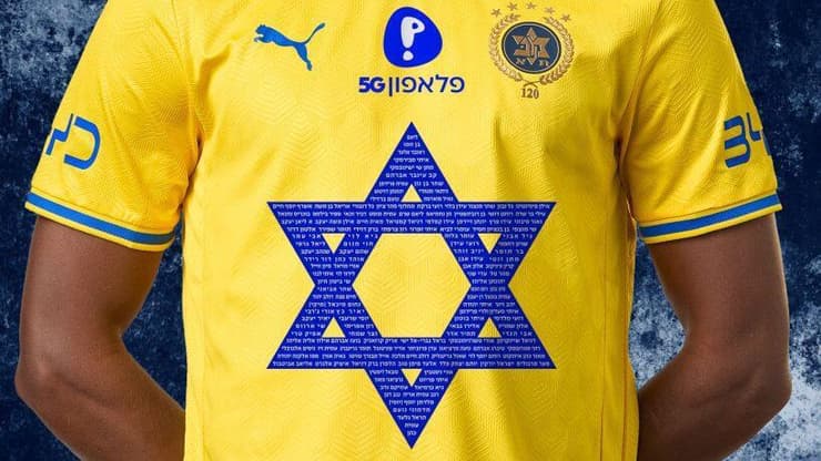 חולצת מכבי ת"א לזכר חללי 7 באוקטובר (צילום מתוך האתר הרשמי של מכבי ת"א) חולצה לזכר חללי 7 באוקטובור