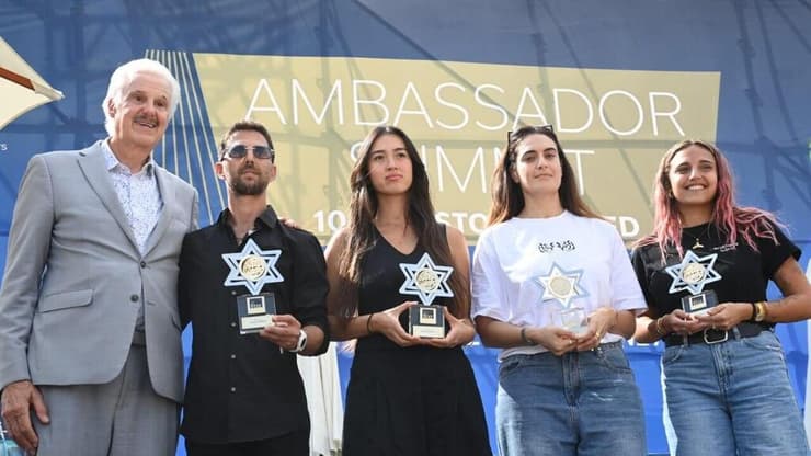 מקבלי האות עם ד"ר אוונס (צילום: הרצל יוסף) שורדי שבי ניצולי הנובה שבים למתחם הפסטיבל באירוע בינלאומי