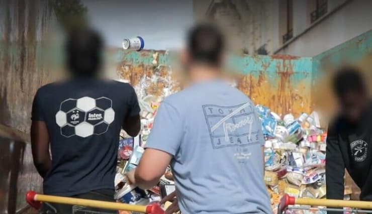 עובדים מפנים מוצרים שאוחסנו במקררים החמים למכולת אשפה ליד סניף של סופרמרקט צרפת מתקפת האקרים על סופרמרקטים עובדים מפנים מוצרים ש התקלקלו למכולת אשפה