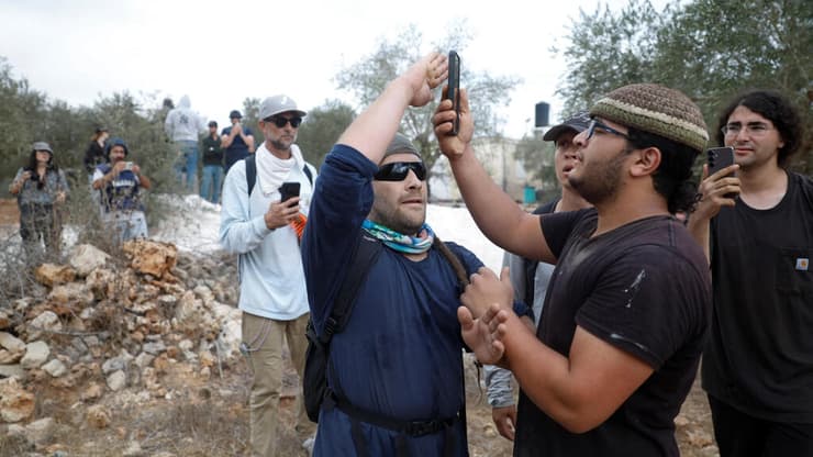 עימות בין מתנחלים לפעילים במסיק זיתים (צילום: REUTERS/Mohamad Torokman) תורמוס עיא ליד רמאללה פעילי שמאל זרים עימותים עם מתנחלים ליד מסיק זיתים של פלסטינים