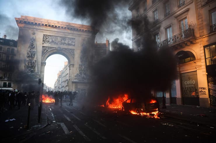 מכונית שהוצתה מול שער סן-דני בפריז (צילום: Kiran RIDLEY / AFP) מהומות פריז צרפת ליד שער סן-דני