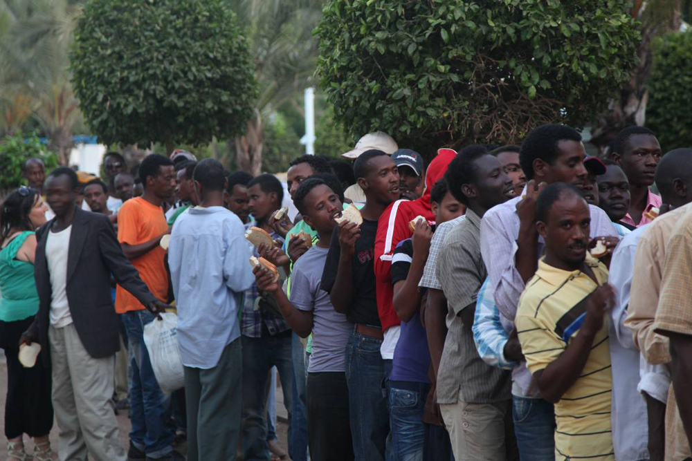 Sudanese refugees standing in line for food in Tel Aviv 
