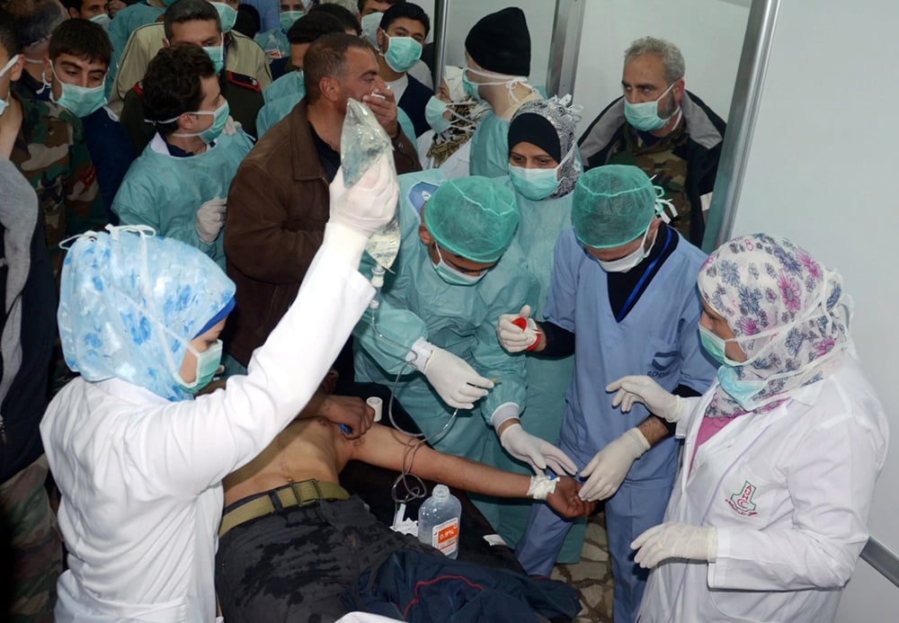 Doctors treat a victim of a chemical attack in Aleppo in 2013 
