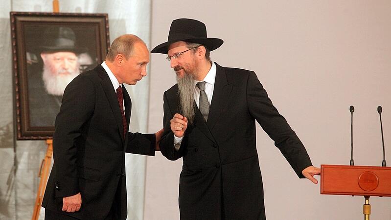 Vladimir Putin with the Chief Rabbi of Russia Berel Lazar with a picture of the Rebbe in the background 