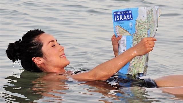 A tourist floating in the water at the Dead Sea 
