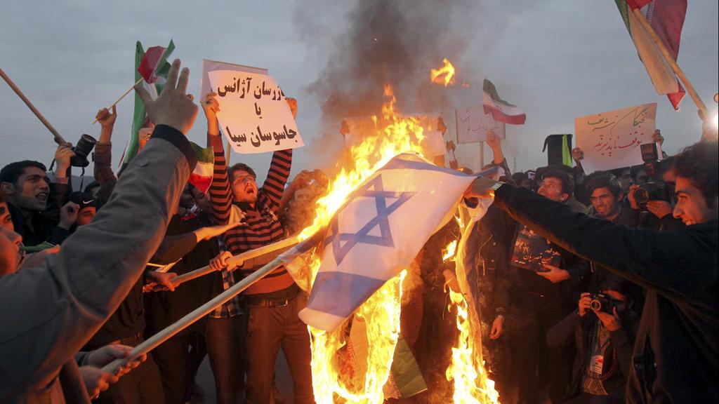 Iranian protesters in Fordo burning an Israeli flag 