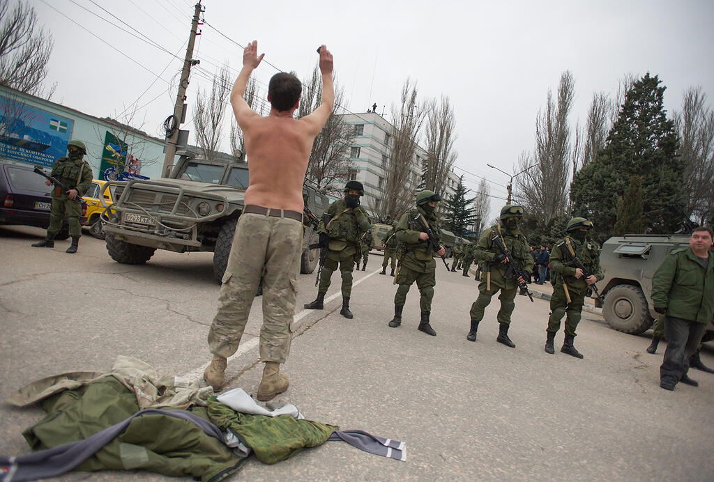 A Ukrainian soldier surrenders to Russian troops in Crimea in 2014 