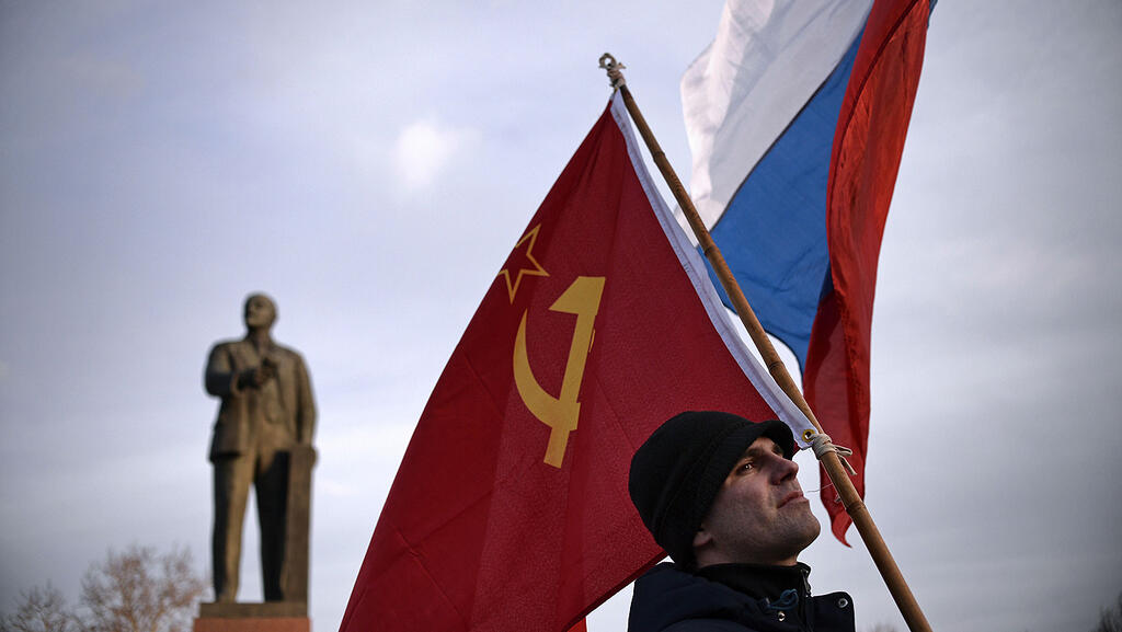 Демонстрант с флагами СССР и РФ 