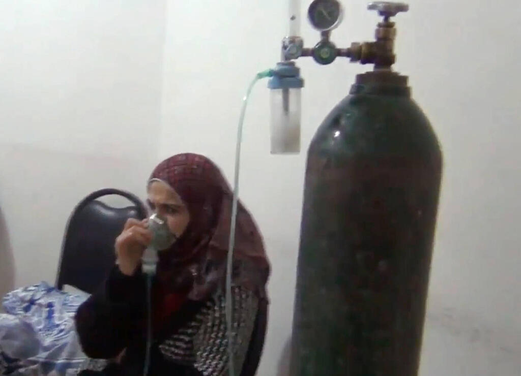 Woman using oxygen tank after inhaling dangerous chemical agents in attack Kafr Zita, Syria, April 26, 2014
