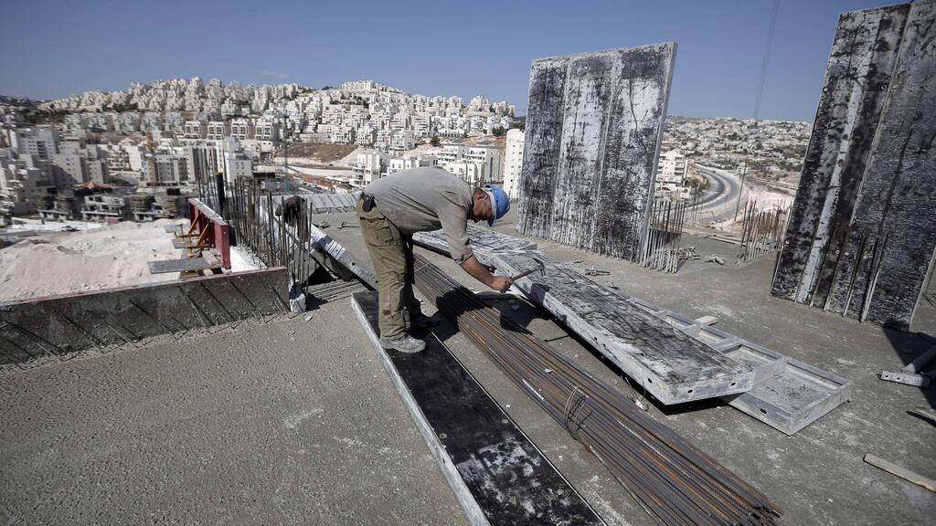 A Palestinian works at a construction site in East Jerusalem 