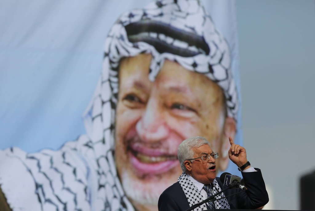 Palestinian President Mahmoud Abbas speaking with an image of his predecessor Yasser Arafat in the background 
