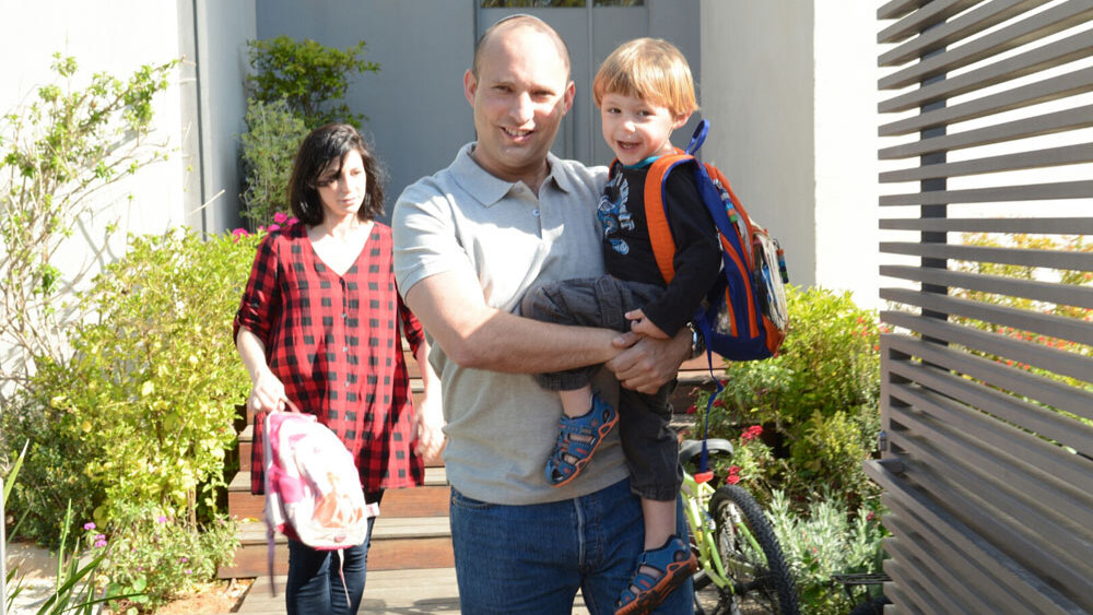 Naftali Bennet with his wife Gilat and his young son outside their home in Ra'anana 