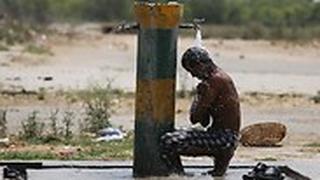 בחור צעיר מנסה להצטנן בחום של הודו     