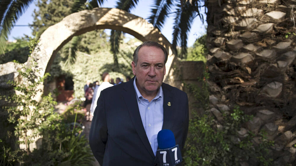 MIke Huckabee talks to reporters during a 2015 visit to Israel