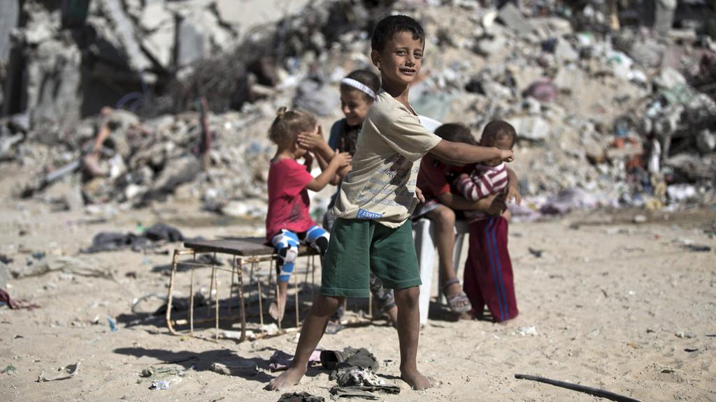 Palestinian children in the rubble in Gaza during the 2014 war 