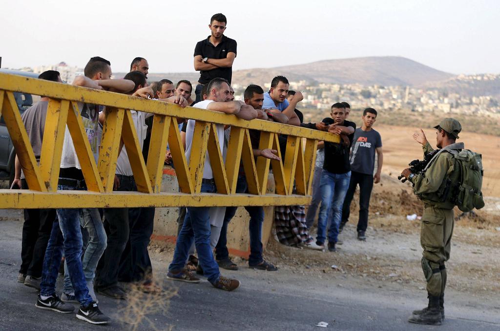 Palestinian workers waiting to cross an IDF crossing near the village of Beit Furik
