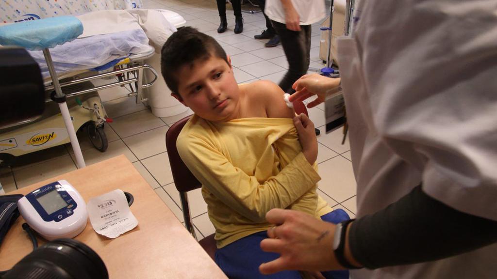 A young boy receives his flu shot 