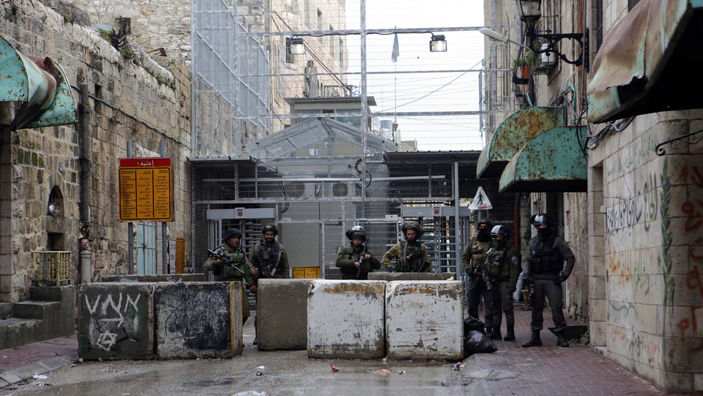 Soldiers guard the empty Al-Shuhada street in Hebron 