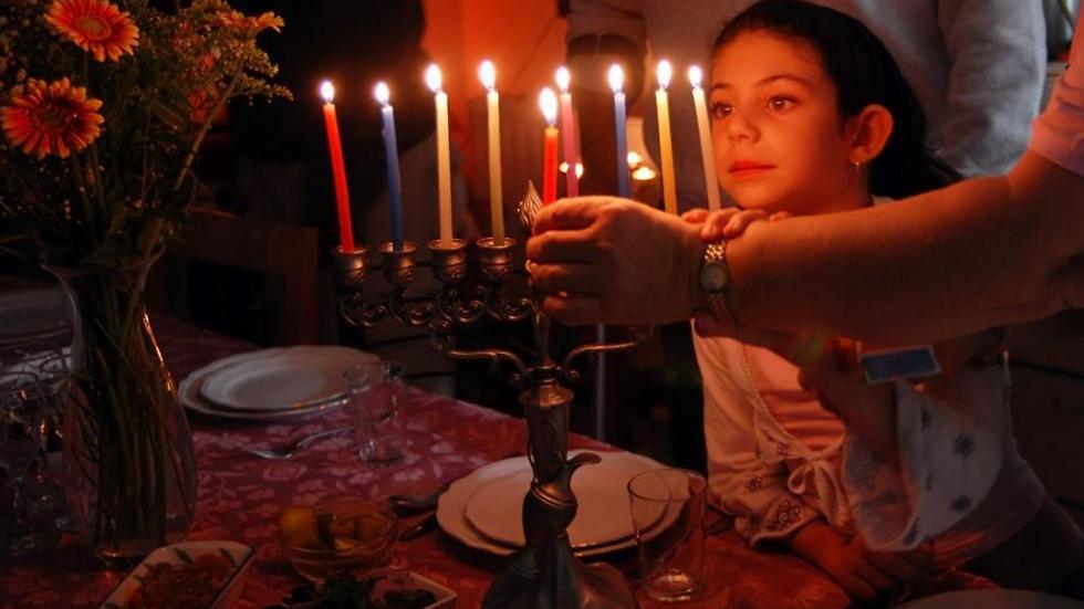 A family lighting the Menorah on Hanukkah 