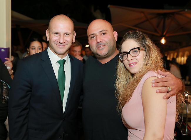 מארח למופת. אסף אטדגי עם אשתו אורלי חג'ג' ומנכ"ל המלון