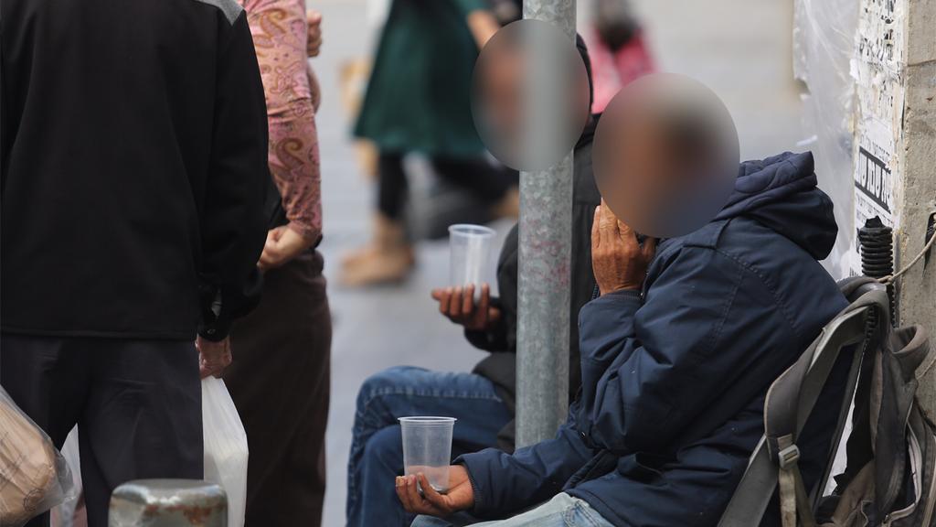 Homeless men begging on the street in Jerusalem 