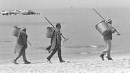 עובדי ניקיון בחוף תל אביב בדרכם לעבודה
