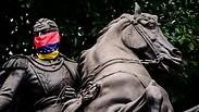פסלו של סימון בוליבאר מכוסה בדגל ונצואלה              