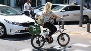 רוכבת על אופניים חשמליים בתל אביב