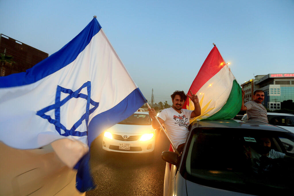 A Kurdish man holding the Israeli and Kurdish flags before the referendum on Kurdistan's independence 