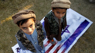 Children in Pakistan step on Israeli, US flags