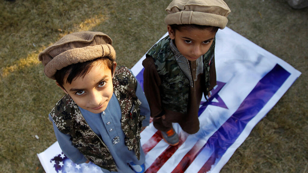Children in Pakistan step on Israeli, US flags
