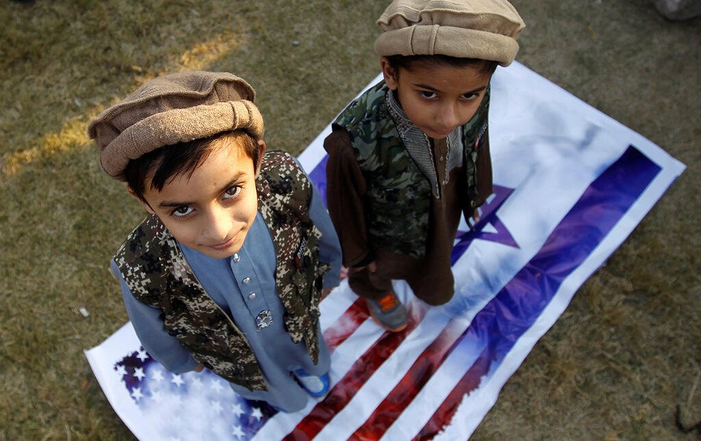 Children in Pakistan stepping on US and Israel flag 