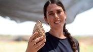מעין שמר, מנהלת החפירה מטעם רשות העתיקות, מציגה אבן יד בת חצי מליון שנה