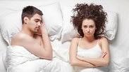 גבר ואישה שוכבים במיטה, האישה כועסת.